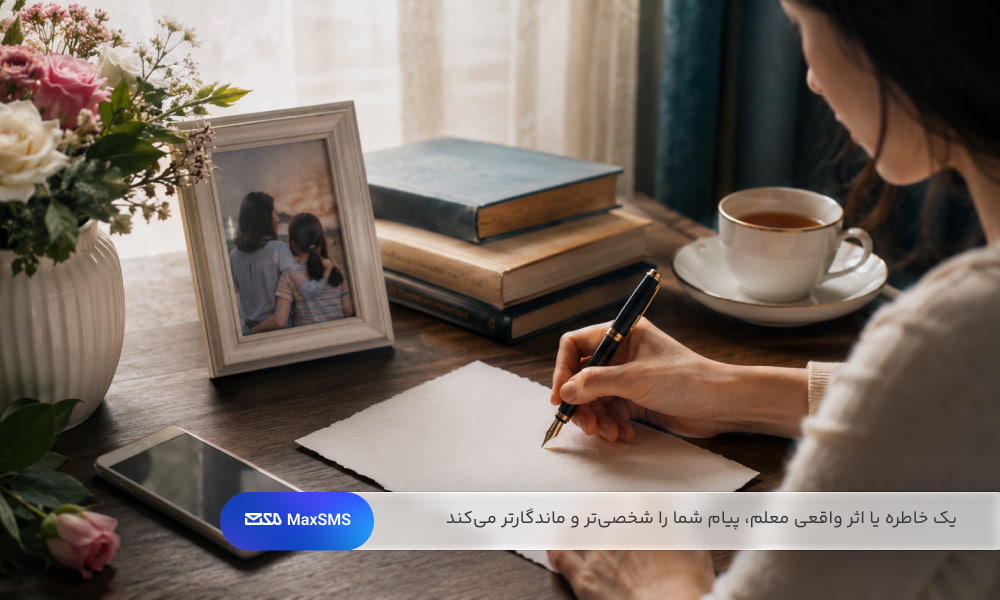 فردی در خانه در حال نوشتن پیام صمیمی و ادبی برای معلم در کنار کتاب، گل و تلفن همراه